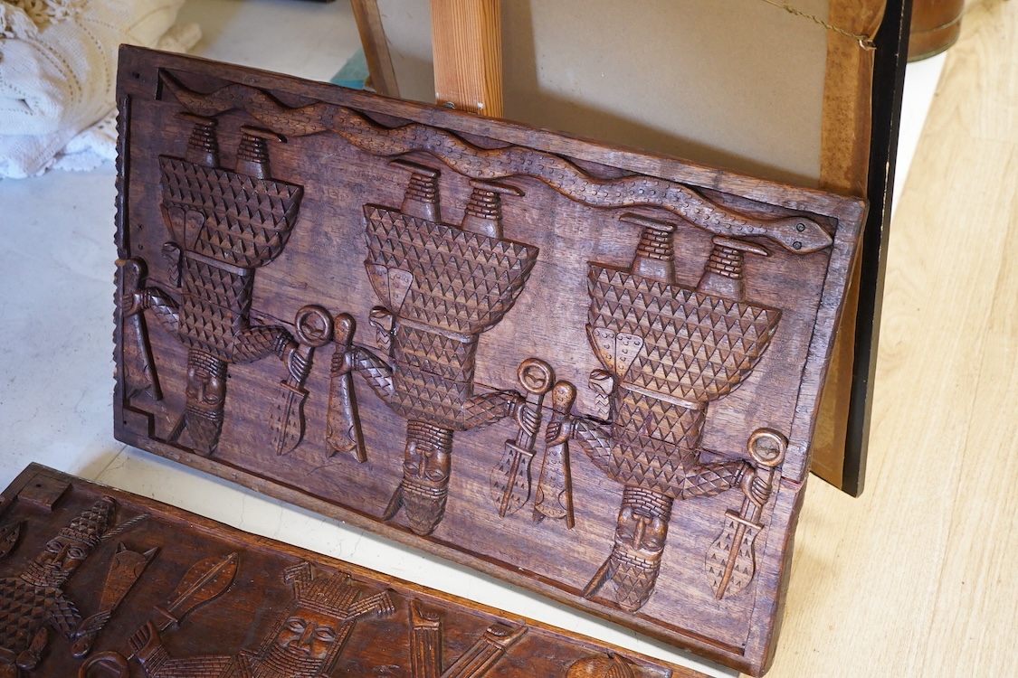 A set of three African carved figurative wooden panels, 64.5cm wide x 37cm high